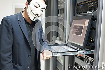 Masked Hacker in Computer Server room Concept . Editorial Stock Photo