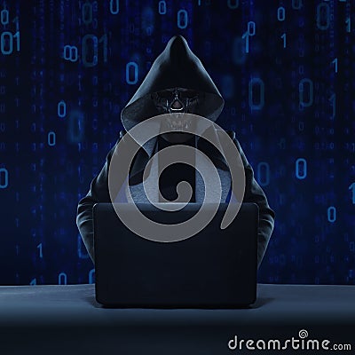 masked hacker using smartphone. Hacking the Internet. Stock Photo