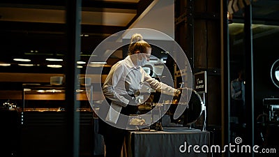 Masked hostess working dark restaurant. Protective measures at covid19 concept Stock Photo