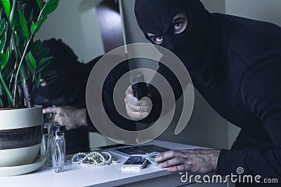 Masked intruder with gun Stock Photo
