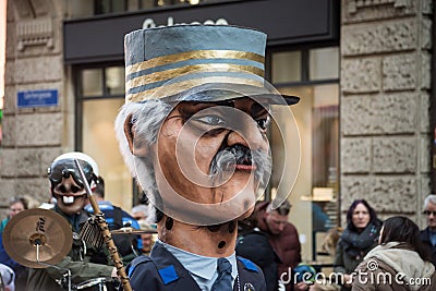 Masked people wearing traditional costume playing music parading in the street Editorial Stock Photo