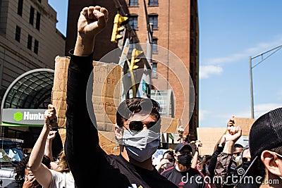 A Masked Protestor Marches and Raises His Fist at Protest for George Floyd Editorial Stock Photo