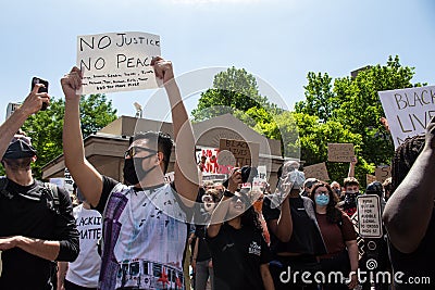 Masked protestors chant and hold signs in protest of the killing of George Floyd Editorial Stock Photo