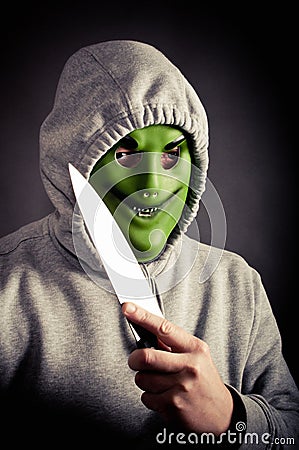 Masked robber holding large knife Stock Photo