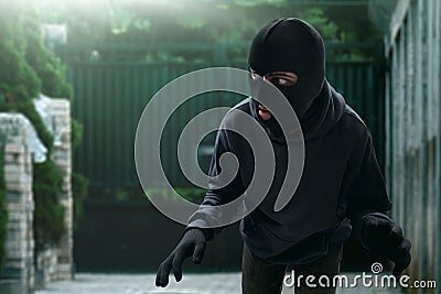 Masked thief sneak to house Stock Photo