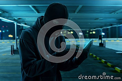 Masked thief using mobile phone Stock Photo