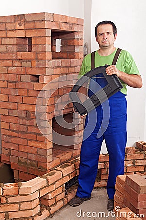 Mason building a traditional stove from bricks Stock Photo
