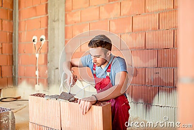 Mason construction worker building brick walls, contractor renovating house. Construction industry details Stock Photo