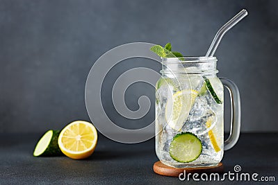 mason jar of cold detox water with cucumber and lemon on grey background Stock Photo