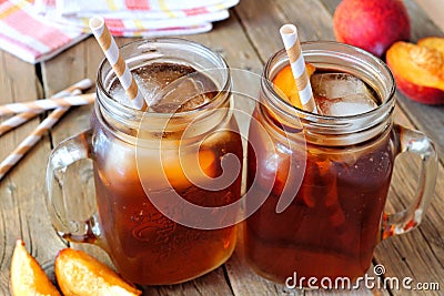 Mason jars of homemade peach iced tea on rustic wood Stock Photo