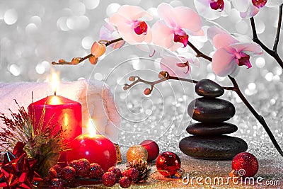Massage composition christmas spa with candles, orchids and black stones Stock Photo