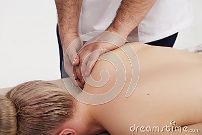 Osteopath does back and shoulder massage to a girl Stock Photo