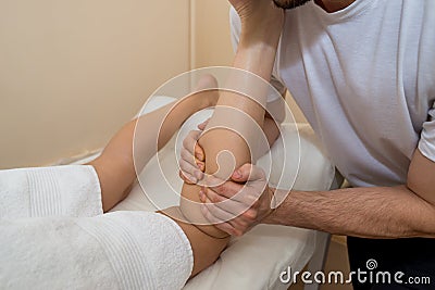 Massage and rehabilitation. Foot massage. The masseur massages the female caviar Stock Photo