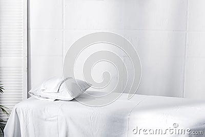 Massage table with white sheet, pillow and towel Stock Photo