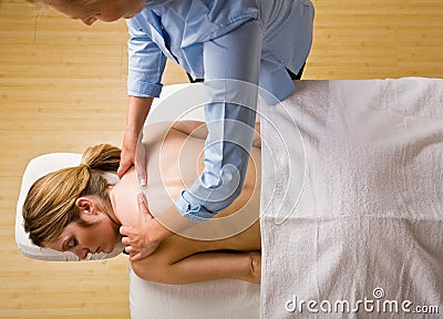 Massage therapist giving woman massage Stock Photo