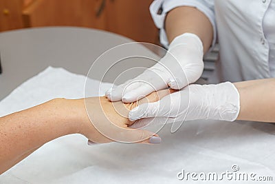 Massage therapist massaging hands of a woman in a beauty salon Stock Photo
