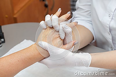 Massage therapist massaging hands of a woman in a beauty salon Stock Photo