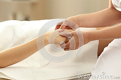 Massage therapist massaging hands of a woman Stock Photo