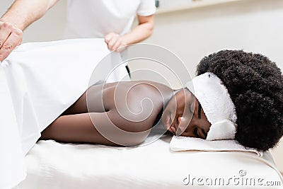 Covering african american woman with bed Stock Photo