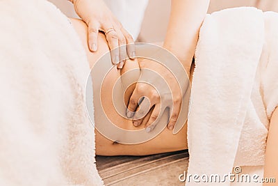Masseur massages patient while lying on side Stock Photo