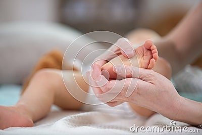 masseur massaging little babys foot Stock Photo