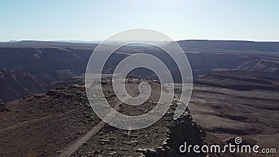 Massive canyon on the background of a tall cliff, sunny day, Namibia. Stunning aerial footage of the tall cliff with the massive Fish River Canyon on the stock footage Massive canyon on the background of a tall cliff, sunny day, Namibia. Stunning aerial footage of the tall cliff with the massive Fish River Canyon on the stock footage