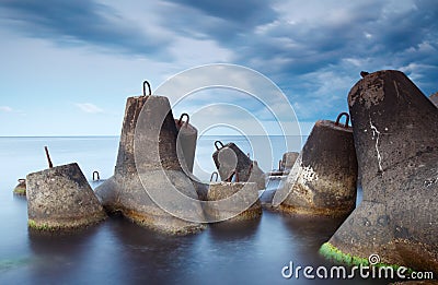 Massive concrete tetrapods form a breakwater with soft blur sea Stock Photo