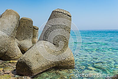 Massive concrete tetrapods form in the green water sea, Greece Stock Photo