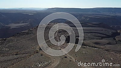 People are walking on a road along the tall cliff, view on the massive canyon. Massive Fish River Canyon on the background of a big cliff with people walking on stock footage People are walking on a road along the tall cliff, view on the massive canyon. Massive Fish River Canyon on the background of a big cliff with people walking on stock footage