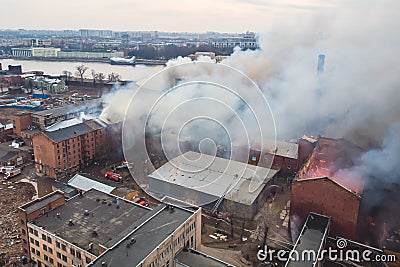 Massive large blaze fire in the city, aerial drone top view brick factory building on fire, hell major fire explosion flame blast Editorial Stock Photo