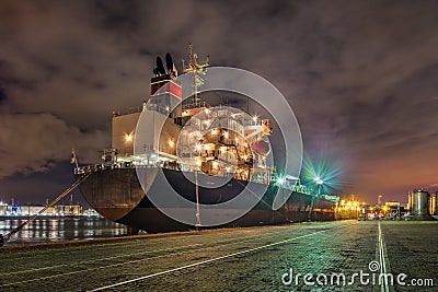 Moored oil tanker at night with a dramatic cloudy sky, Port of Antwerp, Belgium. Editorial Stock Photo