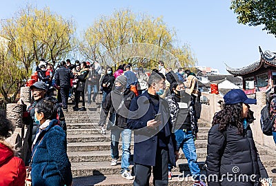 Massive tourists in face masks crossing Puhuitang or Tang Bridge n Qibao Old Town Editorial Stock Photo