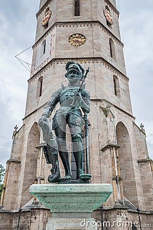 Massive tower of the town church in Balingen and the market fountain well, Germany Stock Photo