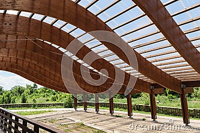 Massive wood beams roof structure with S curved shaped and covered with transparent polycarbonate sheet Stock Photo