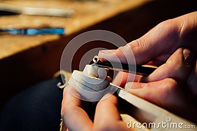 Master artisan luthier working on the creation of a violin. painstaking detailed work on wood. Stock Photo