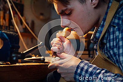 Master artisan luthier working on the creation of a violin. painstaking detailed work on wood. Stock Photo