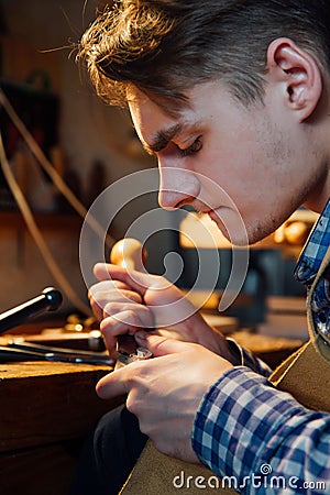 Master artisan luthier working on the creation of a violin. painstaking detailed work on wood. Stock Photo