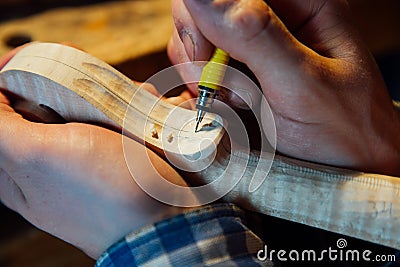 Master artisan luthier working on the creation of a violin. painstaking detailed work on wood. Stock Photo