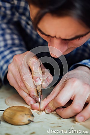 Master artisan luthier working on the creation of a violin. painstaking detailed work on wood. Stock Photo