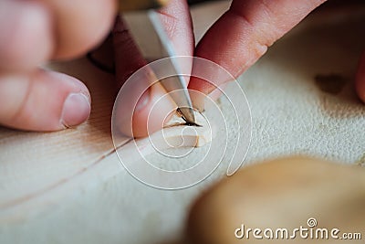 Master artisan luthier working on the creation of a violin. painstaking detailed work on wood. Stock Photo