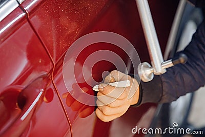 Master auto mechanic removal of dents defects without painting on car body on service station Stock Photo