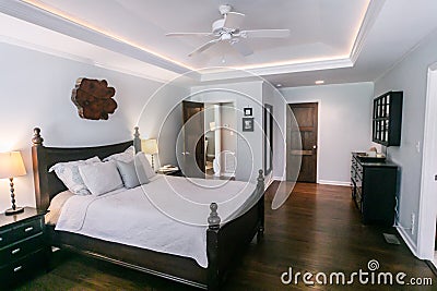 Master bedroom with king size bed and tray ceilings with uplighting and hradwood floors Stock Photo