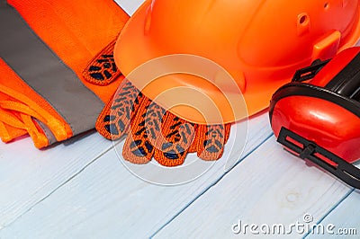 Master builder`s orange protective equipment stacked on blue boards before work Stock Photo