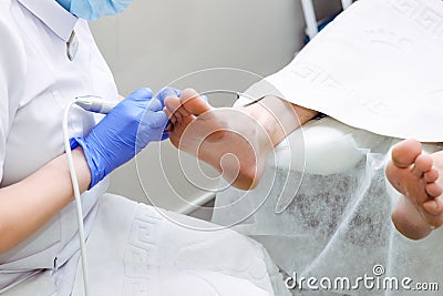 Master chiropody shapes the nails . Male patient in the process of hardware pedicure procedure. Concept body care. Close up, selec Stock Photo