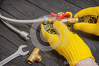 The master connects fittings and plumbing faucet with wrench for a water pipeline Stock Photo