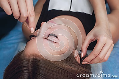 Master corrects makeup gives shape and thread plucks eyebrows Stock Photo
