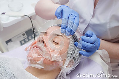Master creates a mask on the face of a young girl Stock Photo