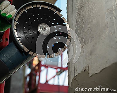 Master cuts a concrete wall with a circular diamond saw. Stock Photo