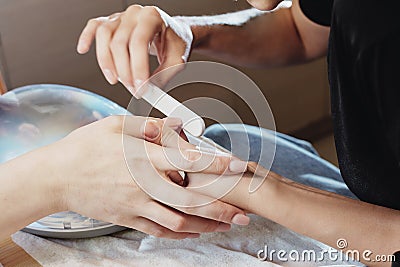 The master does a manicure to the client. saws his nails with an abrasive gray saw. Other nails are ready. close-up Stock Photo