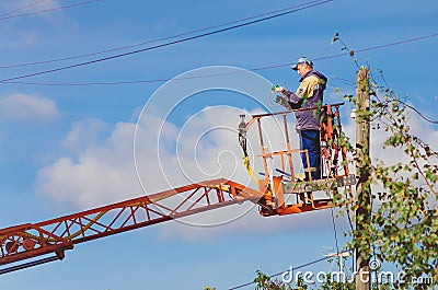 Master electrician works on the pole. Editorial Stock Photo